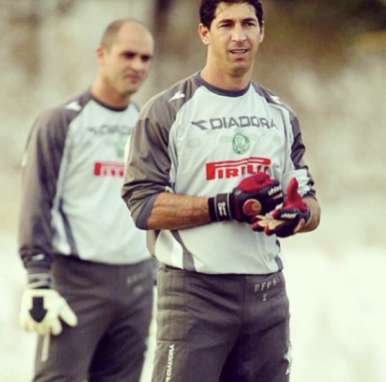 Marcos e Sérgio de uniforme cinza de goleiro em treino do Palmeiras, com Sérgio à frente ajustando a luva