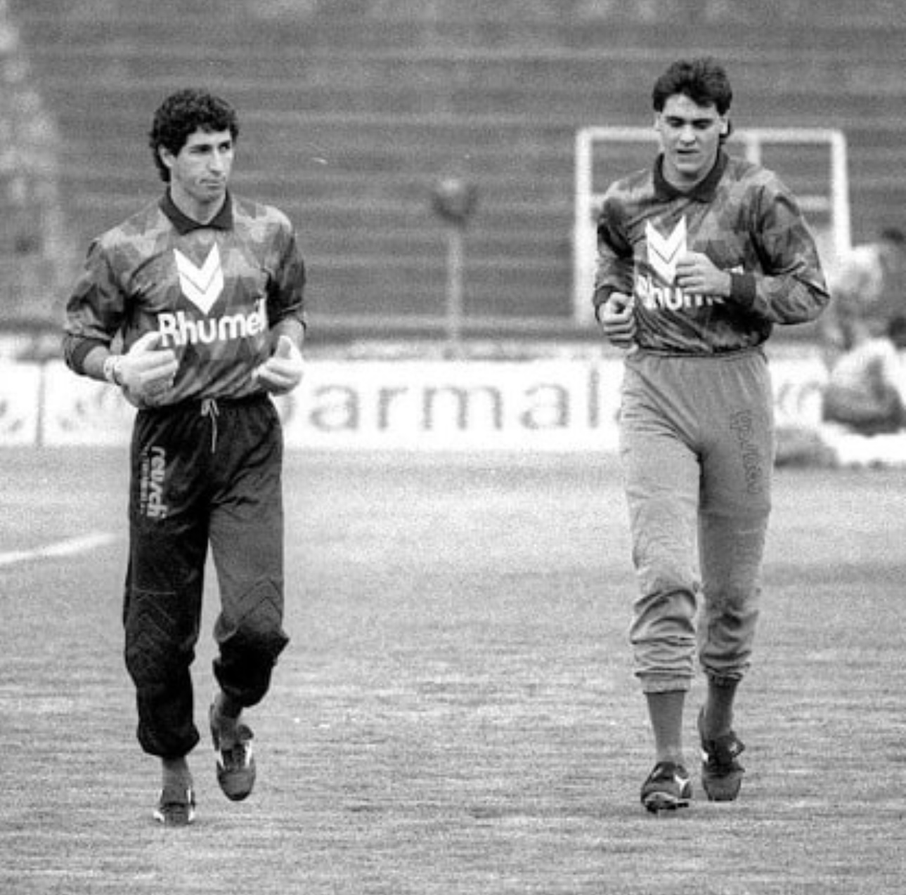 Sérgio e Marcos jovens caminhando no gramado com o agasalho do Palmeiras dos anos 90, em foto preto e branco